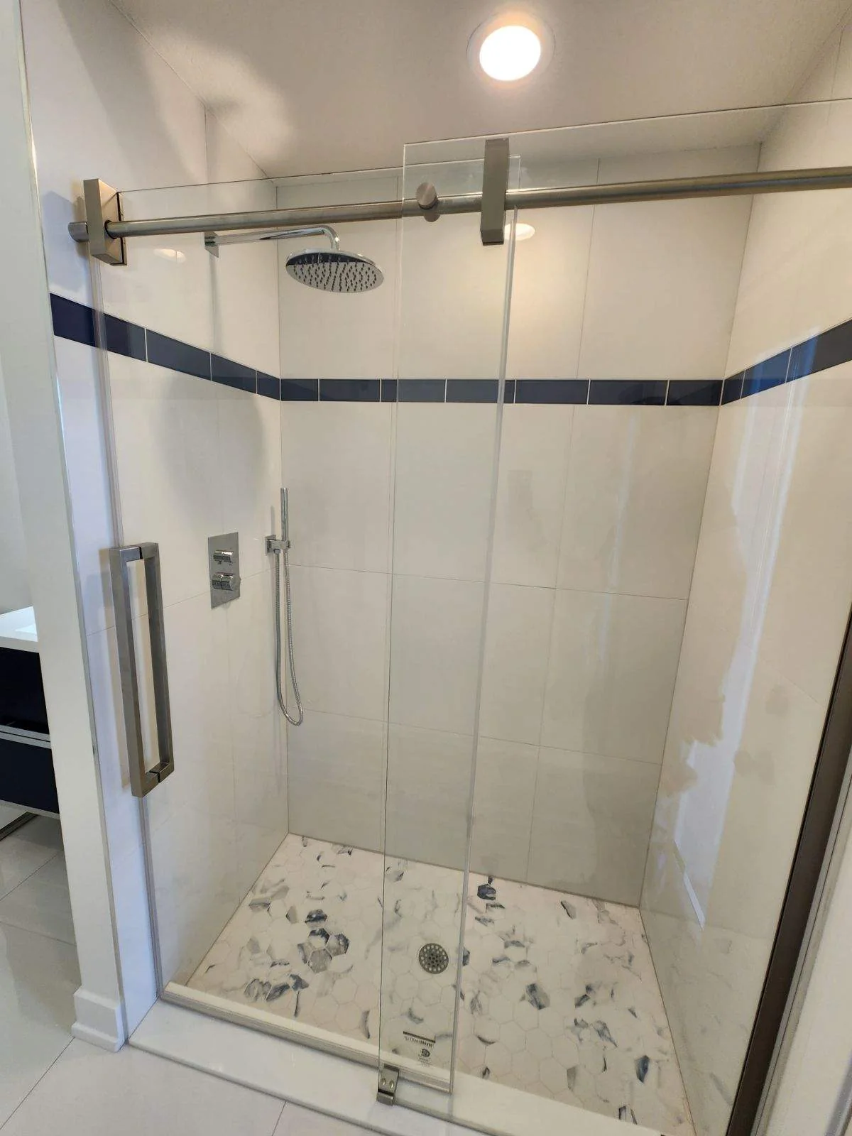 Finished bathroom shower with glass enclosure and tile