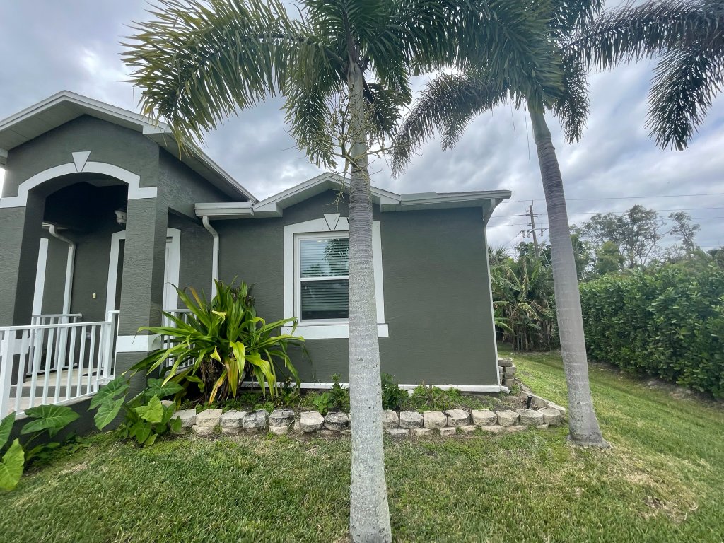 Front exterior of a repainted Florida home with palm trees
