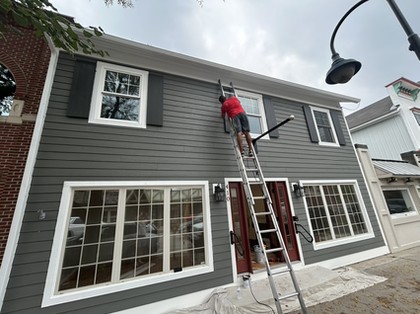Royal Renovations exterior painting work from a ladder