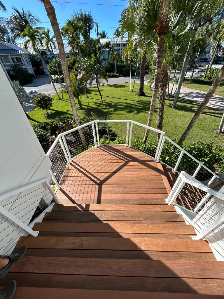 Finished Royal Renovations deck stairs and railing overlooking a Florida landscape