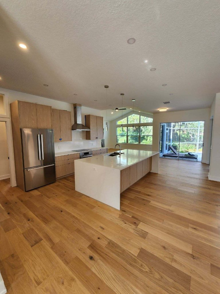 Finished Royal Renovations kitchen and living space with wood flooring